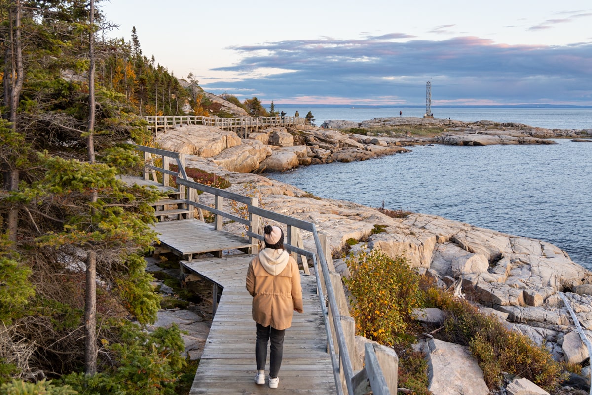 Personne qui marche sur le sentier de la Pointe de l'Islet qui longe le fleuve Saint-Laurent